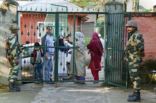 Security personnel stand guard as voters arrive to cast their votes at a polling booth in Budgam, Kashmir. (Photo: PTI) Photo for Representation Purpose only.