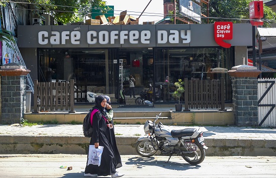 Women walk past a closed Cafe Coffee Day (CCD) outlet in Srinagar on July 31, 2019. CCD's owner VG Siddhartha committed suicide by jumping in the River Netravathi near Mangaluru. (Photo: PTI)