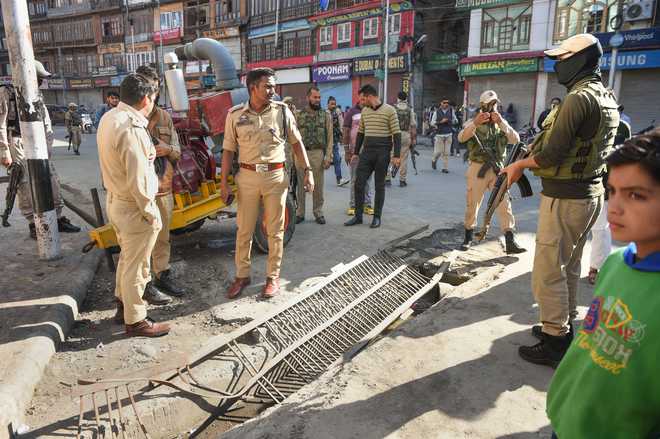 J&K Police personnel inspect the grenade blast site at Hari Singh High Street in Srinagar on October 12, 2019. (Photo: PTI)