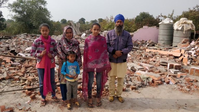 A Sikh family stands in front of their demolished house at Karahal, Madhya Pradesh. (Photo: HT)