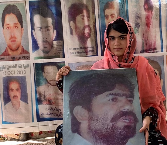 Sammi Baloch with the photo of her father Dr Deen Mohammad. Twelve years ago the Pakistani security forces abducted Dr Deen Mohammad from Khudzar, Balochistan. (Photo: News Intervention)